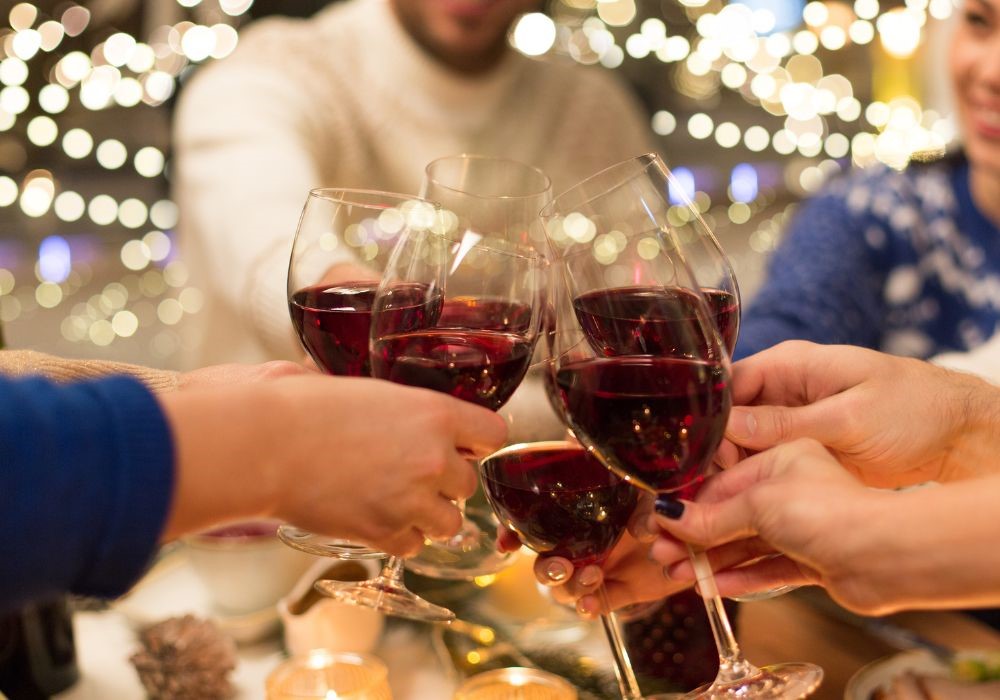 Amici che brindano a Natale su un tavolo decorato